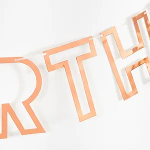 Rose gold birthday banner detail, hollow letter garland decoration for party setup.