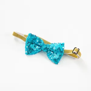 Close-up of a sparkly blue sequin pet bow tie with gold elastic strap and adjustable buckle.