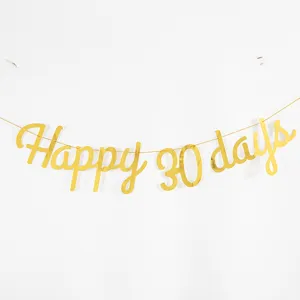 Detail view of gold letter banner spelling happy 30 days for baby party decoration