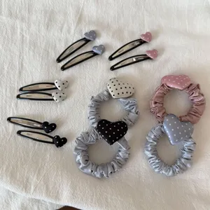 Detail van haarklemmen en scrunchies met hartjes en stippen, schattige accessoires.