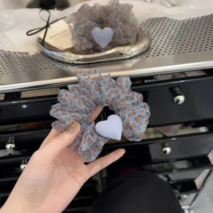 Blue leopard print hair scrunchie with cute heart charm, elegant daily hair accessory detail.