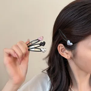 Gedetailleerd overzicht van schattige hartvormige haarspelden met stipjes, stijlvolle zwarte clips.