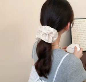 Detailed view of the Korean floral lace scrunchie worn on a ponytail, showing soft fabric texture.