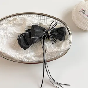 Detail view of a sweet black denim bow hair banana clip featuring long ribbons and crystal.