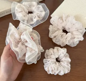 Detailed shot of Korean floral lace hair scrunchies with sheer mesh ruffles, soft fabric.