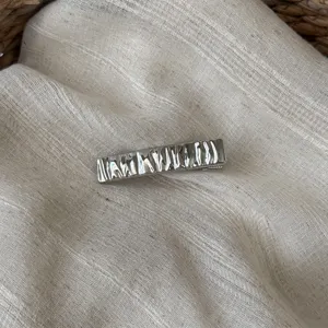 Metallische gewellte Haarklammer Detail, silberner Entenschnabel Clip für elegantes Styling.