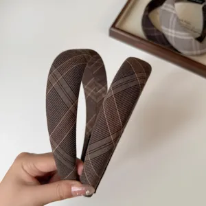 Primer plano detallado de la diadema acolchada de cuadros marrones con textura de tela.