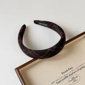 Primer plano detallado de la diadema acolchada a cuadros marrón oscuro con textura.
