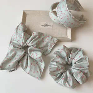 Detalle de scrunchies y diademas florales verde claro, accesorios de pelo estilo dulce.