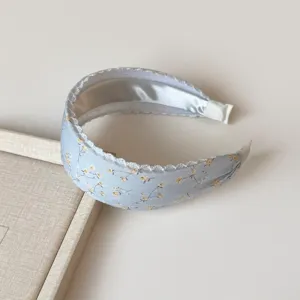 Primer plano detallado de diadema floral azul claro con delicado borde de encaje