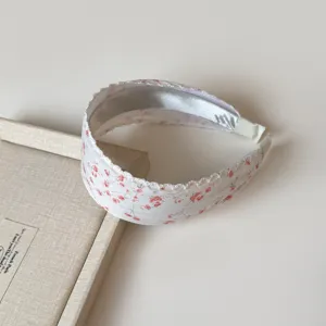 Primer plano detallado de una diadema floral de estilo pastoral dulce, tela suave.