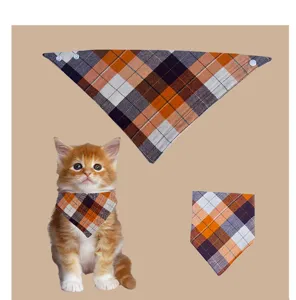 Detailed view of the orange plaid pet bandana, showing fabric texture and snap buttons.