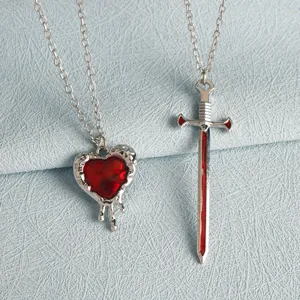 Detail view of matching heart and sword couple necklaces, stylish silver jewelry gift set.