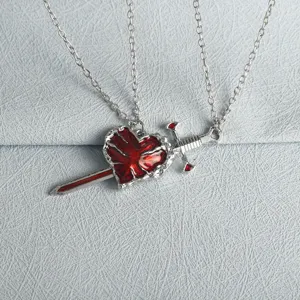 Close-up detail of the gothic style silver-tone sword piercing red heart pendant necklace.