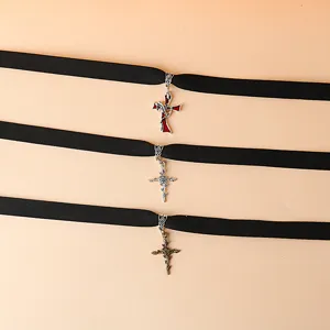 Close-up detail of gothic black velvet choker necklace featuring ornate metal cross pendant.