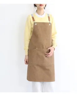 Detailed view of the thickened canvas apron featuring cross-back straps and front utility pockets.