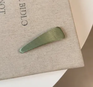 Dettaglio fermaglio capelli raso verde, molletta lucida per styling frangetta carina ed elegante.