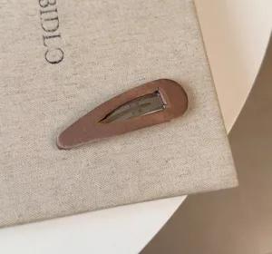 Primo piano del fermaglio per capelli in raso marrone lucido, elegante accessorio quotidiano.