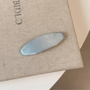 Elegante fermaglio per capelli in raso azzurro per donne, accessorio lucido per stile quotidiano.