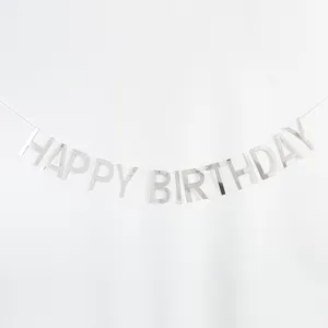 Silver happy birthday letter banner detail, shimmering foil party decoration close-up view.