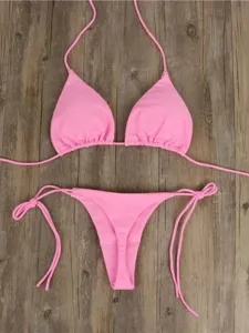 Women's pink two-piece bikini swimsuit, sexy halter neck and side-tie thong for summer.