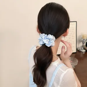 Chic light blue scrunchie detail shot featuring lovely heart polka dots and pleated fabric design.