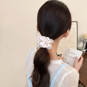 Detailed shot of sweet Korean style polka dot pleated hair scrunchie worn on ponytail.