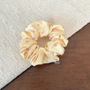 Korean style sweet yellow satin hair scrunchie with cute pink heart print, chic hair accessory.