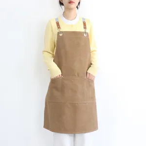 Brown thick canvas apron with leather straps and large pockets for kitchen coffee shop work wear