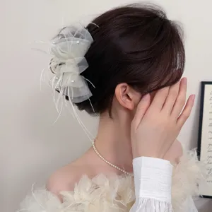 Detailed view of elegant mesh feather hair claw clip with pearls for chic hair styling.
