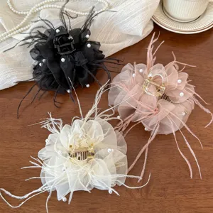 Detail shot of elegant mesh feather pearl hair claw clip, exquisite textured accessory for styling.