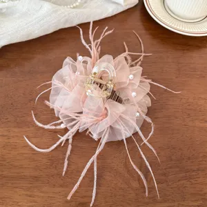 Detail view of the elegant pink feather mesh hair claw clip decorated with faux pearls.