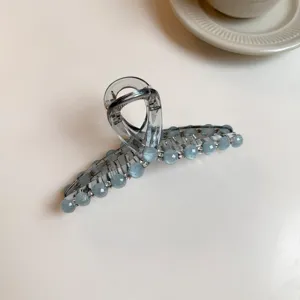 Gros plan detaille montrant les magnifiques strass scintillants et le design de la pince a cheveux.