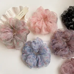 Detailed view of dreamy organza floral print hair scrunchies with shimmering glitter details.