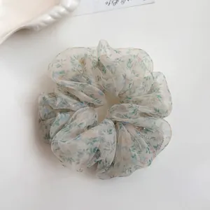 Close-up detail of the floral organza hair scrunchie, showing soft fabric and delicate print.