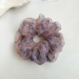 Detailed shot of a romantic fluffy organza rhinestone printed hair scrunchie for women.