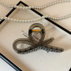 Elegante molletta per capelli incrociata in acrilico per acconciature da donna. Vista dettaglio.