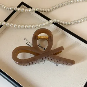 Molletta per capelli in acrilico marrone dettaglio, elegante design a croce per donne.