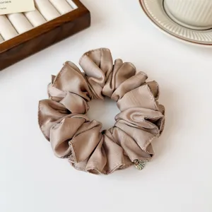Hoogwaardige effen geplooide satijnen haarscrunchie met elegant gouden hangerdetail voor dames.