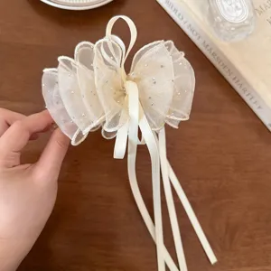 Elegante molletta per capelli con fiocco in tulle e strass scintillanti per look chic.
