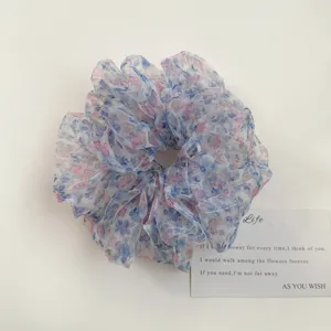 Nahaufnahme der floralen Organza Haargummi Details mit feinem blau rosa Ölgemälde Druck.