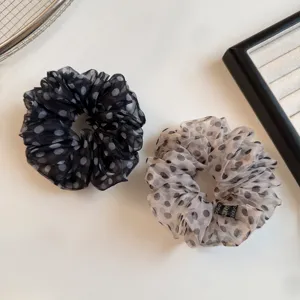 Nahaufnahme Detail des flauschigen gepunkteten Organza Haargummis für elegante Frisuren.