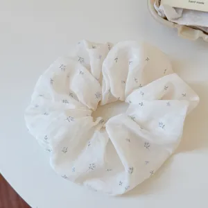Close-up detail of the white floral scrunchie with delicate blue tulip prints for daily wear.