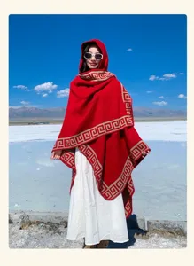 Detalle de viaje escénico de la capa roja con capucha y elegante diseño de greca tradicional.