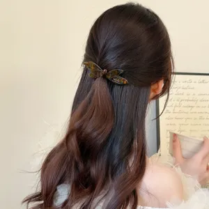Detalle de pinza de pelo de mariposa de acetato, elegante clip carey para peinados chic.