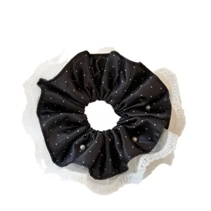 Black satin polka dot hair scrunchie with white lace and pearls. Elegant and stylish hair accessory for women.
