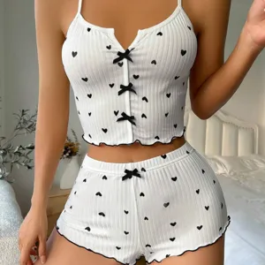Set pigiama a due pezzi in tessuto a costine bianche con cuori neri e dettagli di fiocchi.