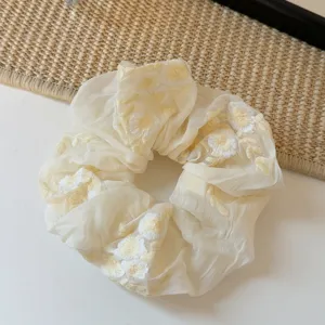 Λεπτομέρεια scrunchie με κέντημα κίτρινων λουλουδιών, μαλακό αξεσουάρ μαλλιών για γυναίκες.