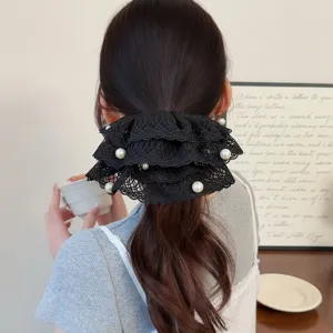 Close-up detail of a black lace pearl hair scrunchie worn in an elegant ponytail.