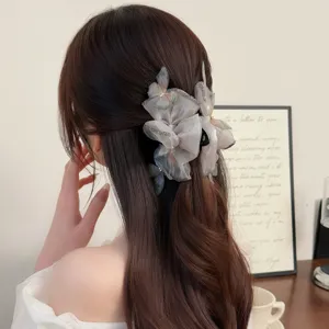 Nahaufnahme der Organza Schmetterling Haarklammer mit funkelndem Stoff und elegantem Design.